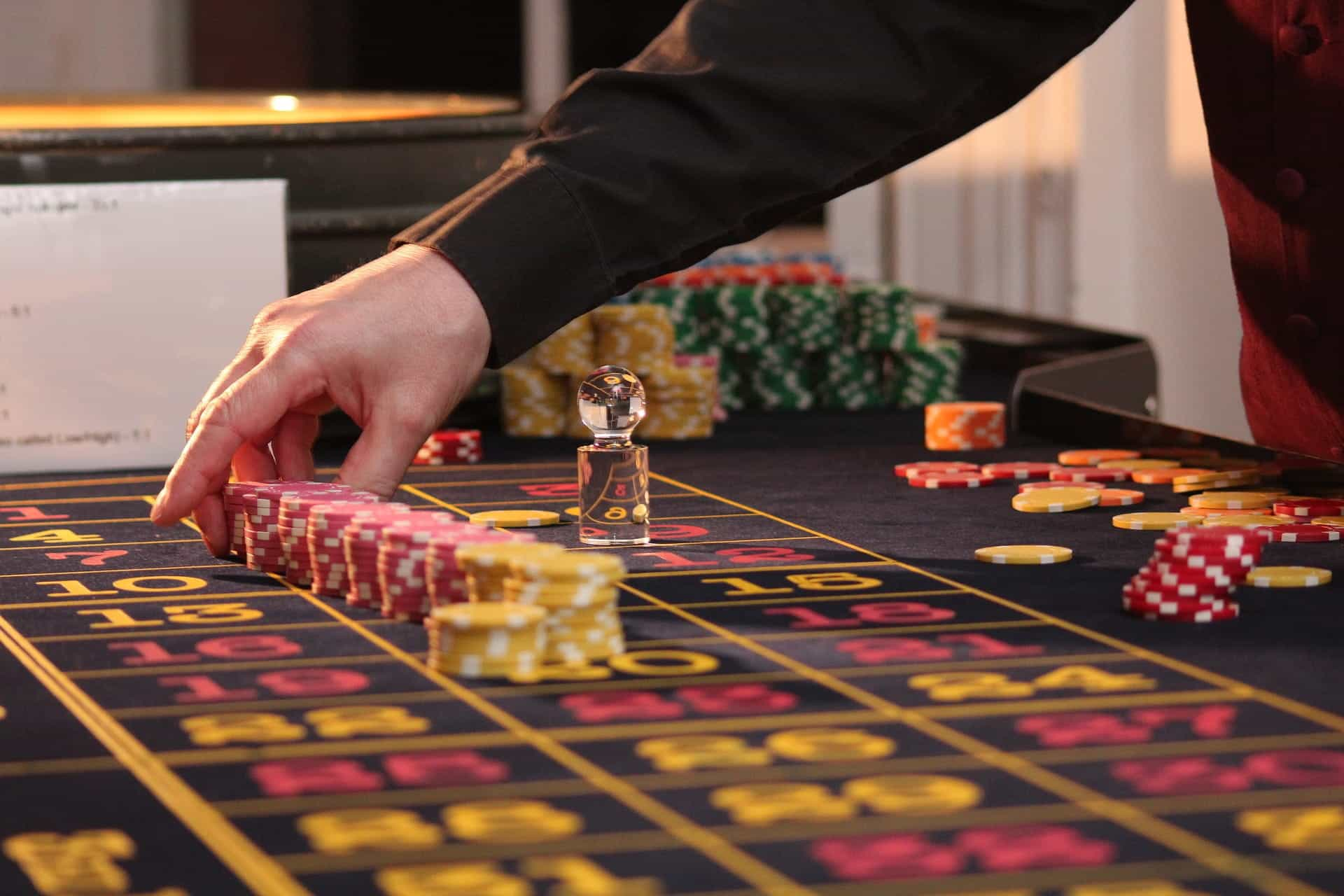 A casino dealer places chips on the table.