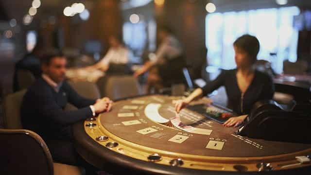 A blackjack casino worker deals cards.