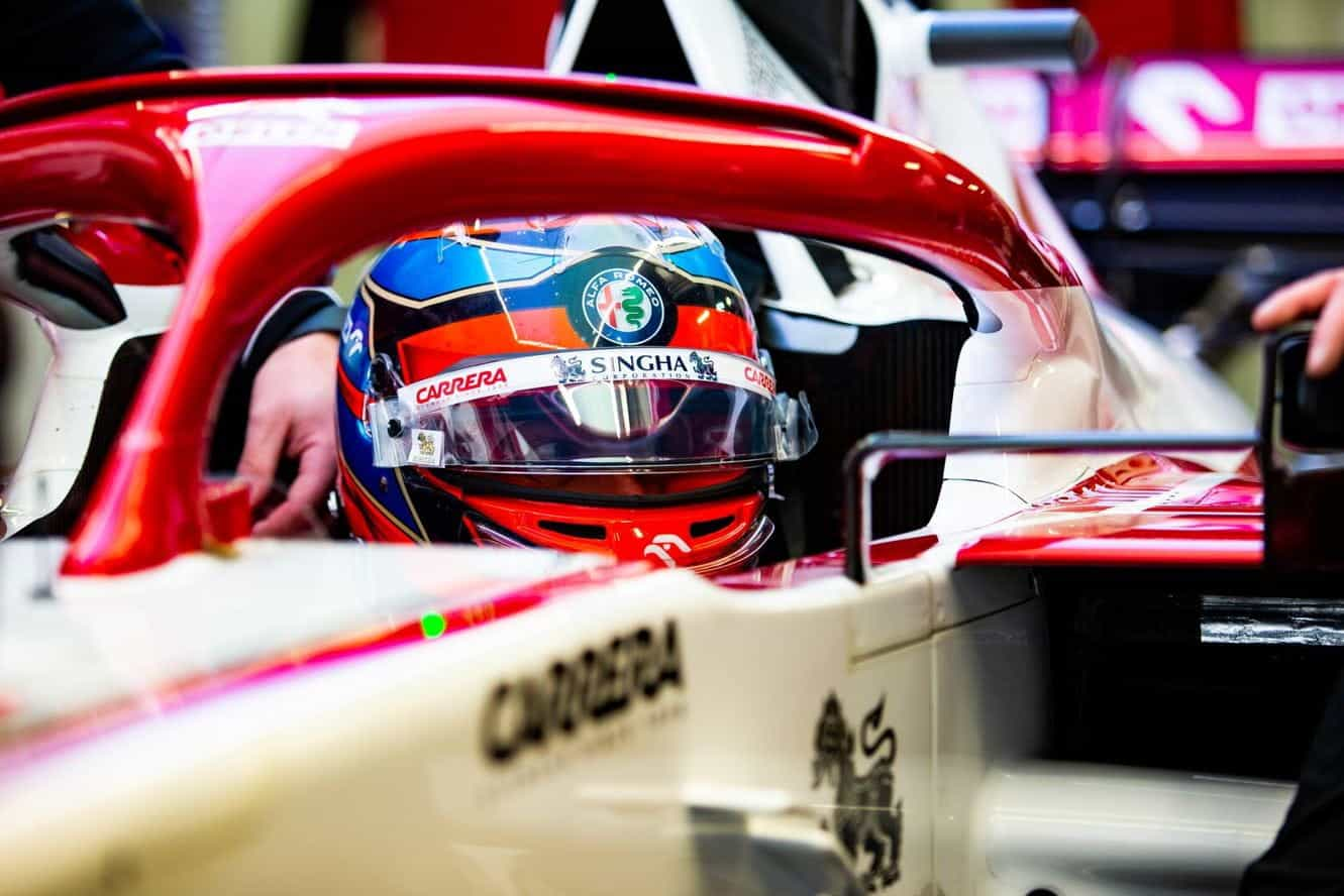 The driver and cockpit of an Alfa Romeo F1 car.