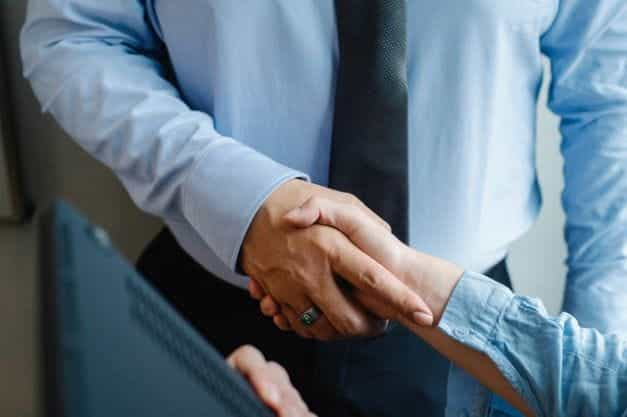 A businessman shaking hands with another person.