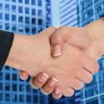 A handshake in front of an office building.