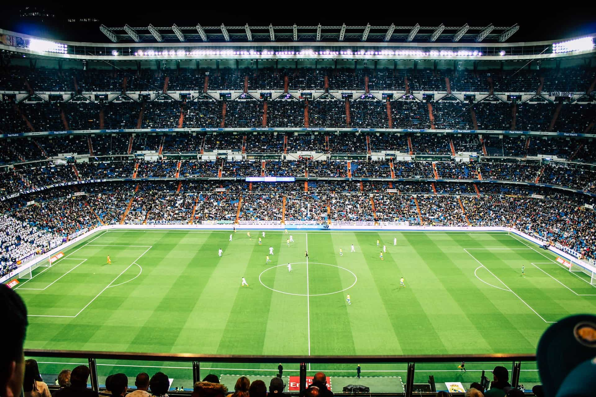 The inside of a large soccer stadium at night.