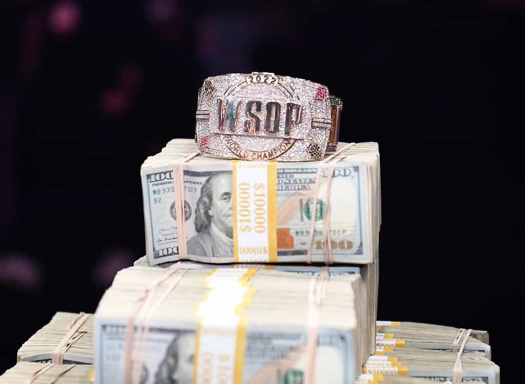 A huge pile of American dollars with a World Series of Poker bracelet sat on it.