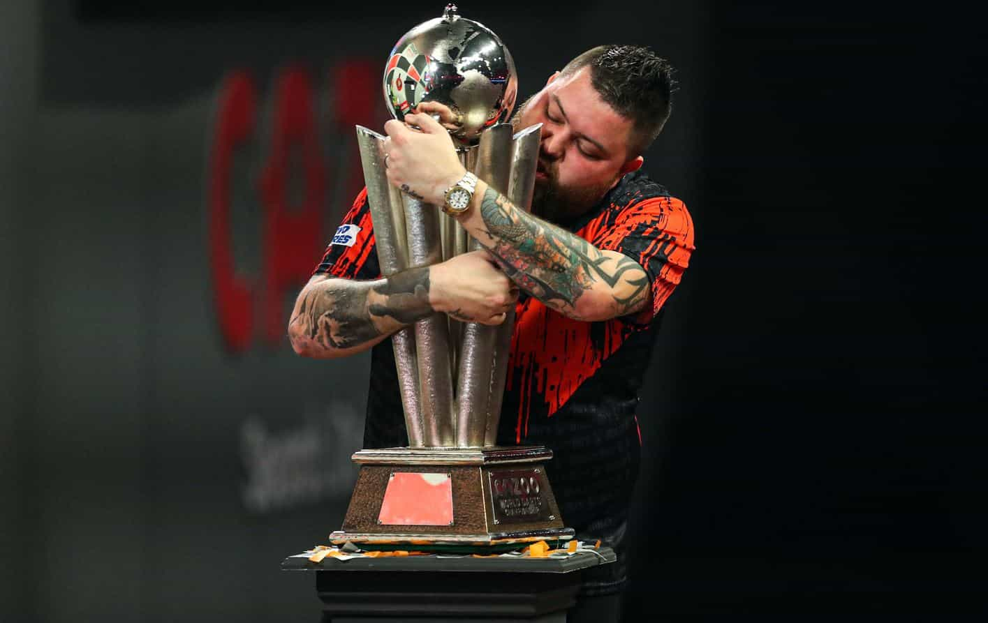 Michael Smith clutches the PDC World Darts Championship trophy he won in 2023.