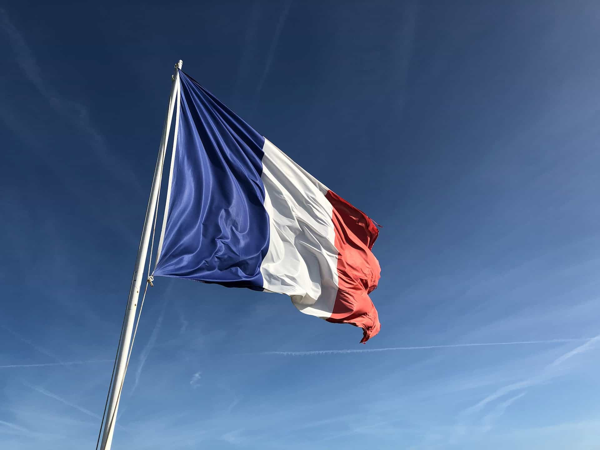 A blue, white, and red flag under the blue sky.