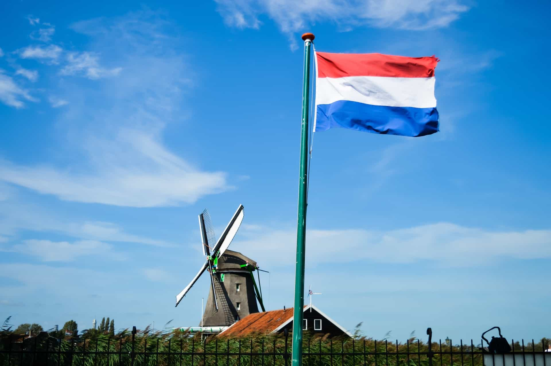 A flag against the blue sky on a pole.