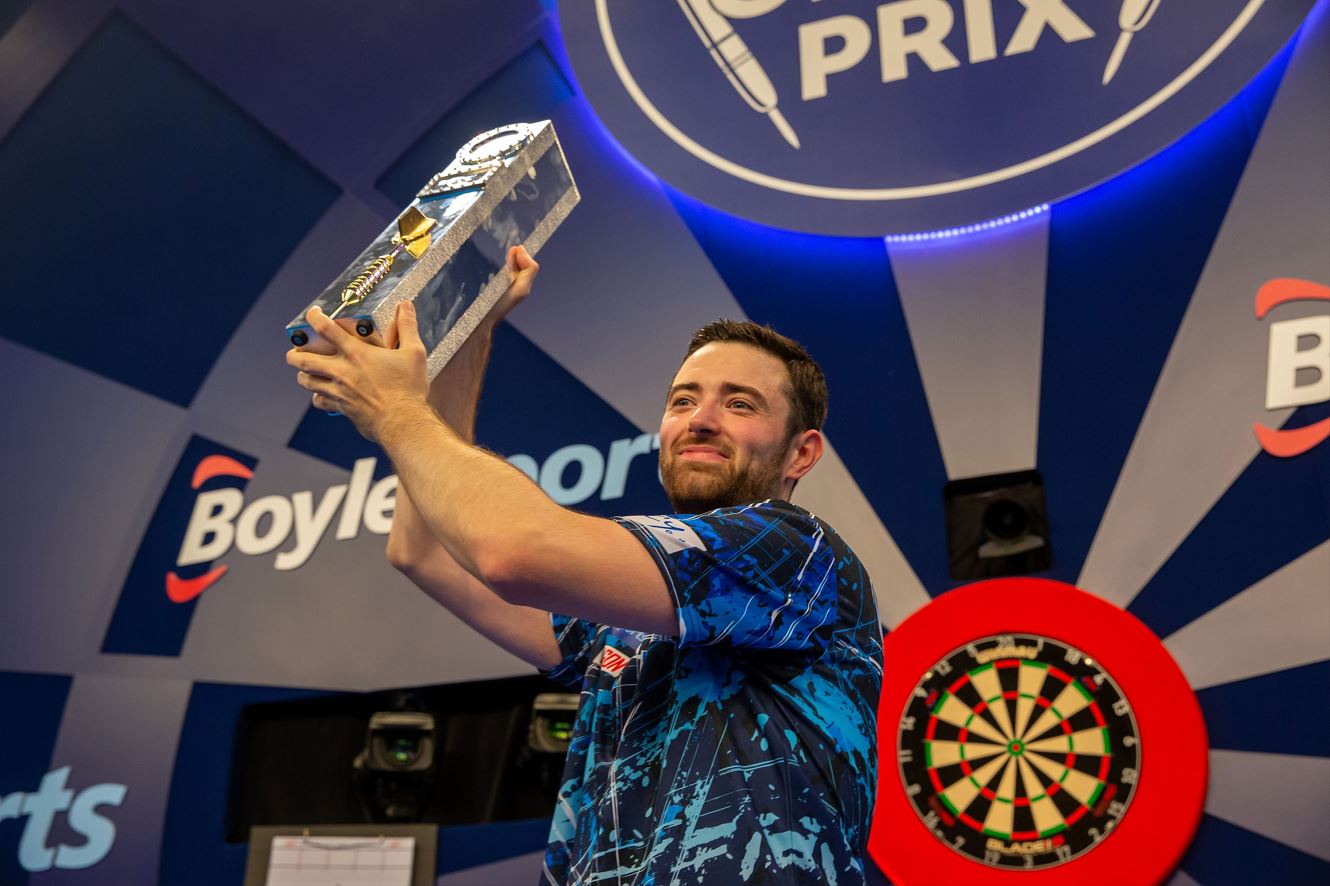 Luke Humphries lifts his 2023 World Grand Prix winner’s trophy.